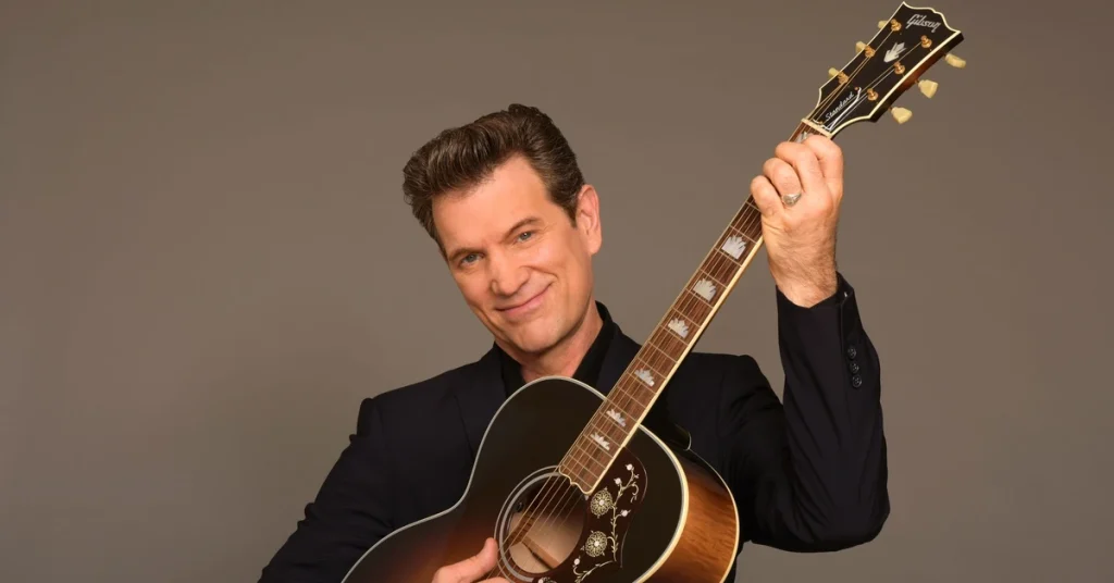 Chris Isaak portrait studio avec guitare Gibson 2026