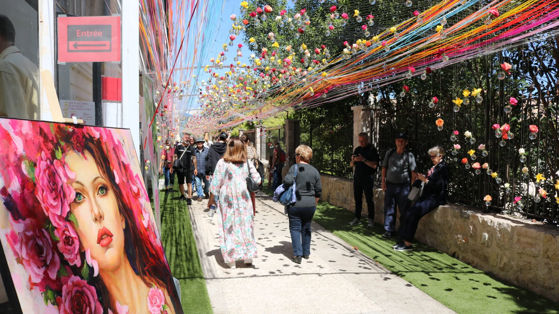 Allée tapissée de tableaux et fleurs colorées