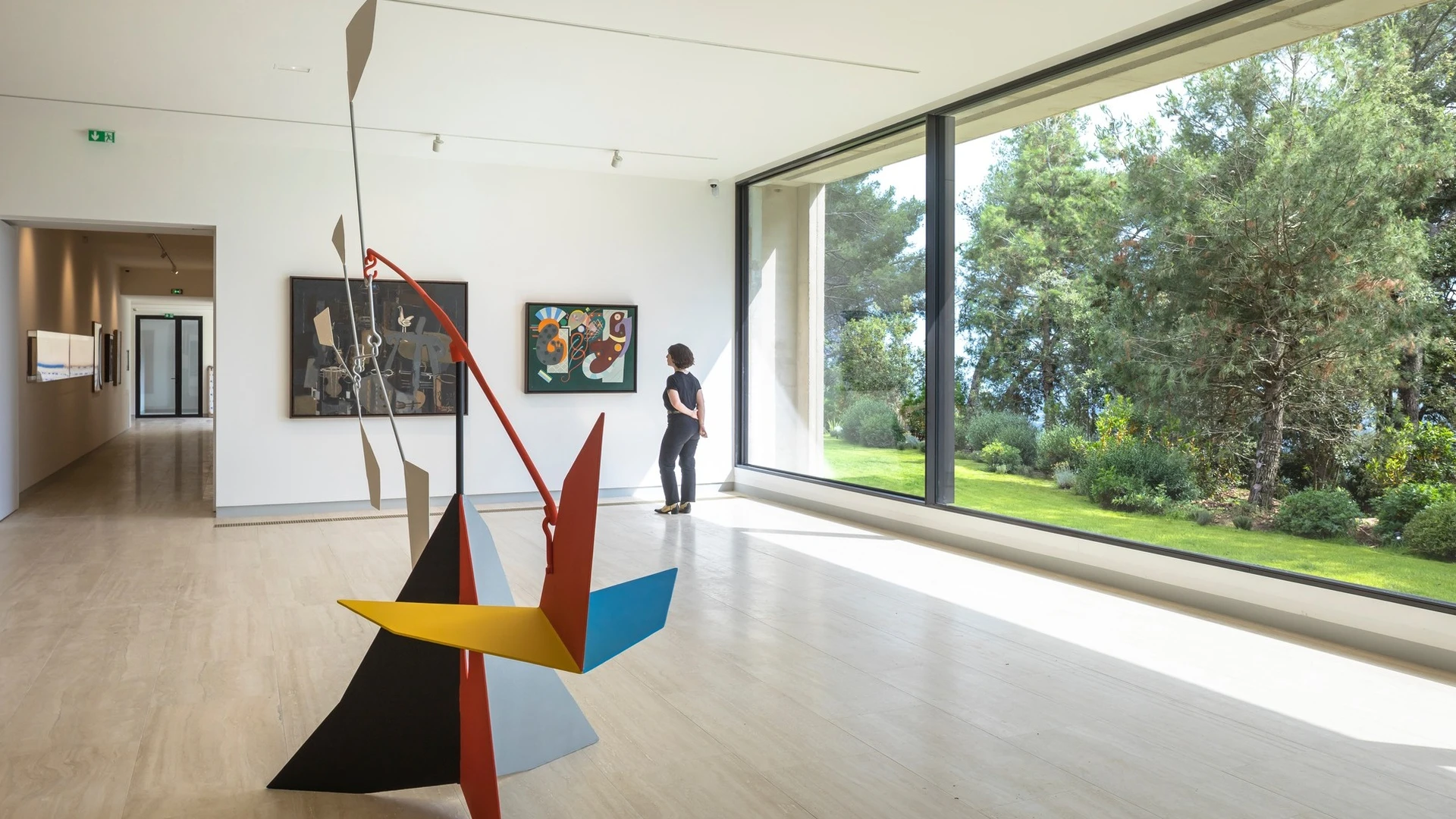 Intérieur de la Fondation Maeght avec mobile coloré d'Alexander Calder et baie vitrée donnant sur le jardin