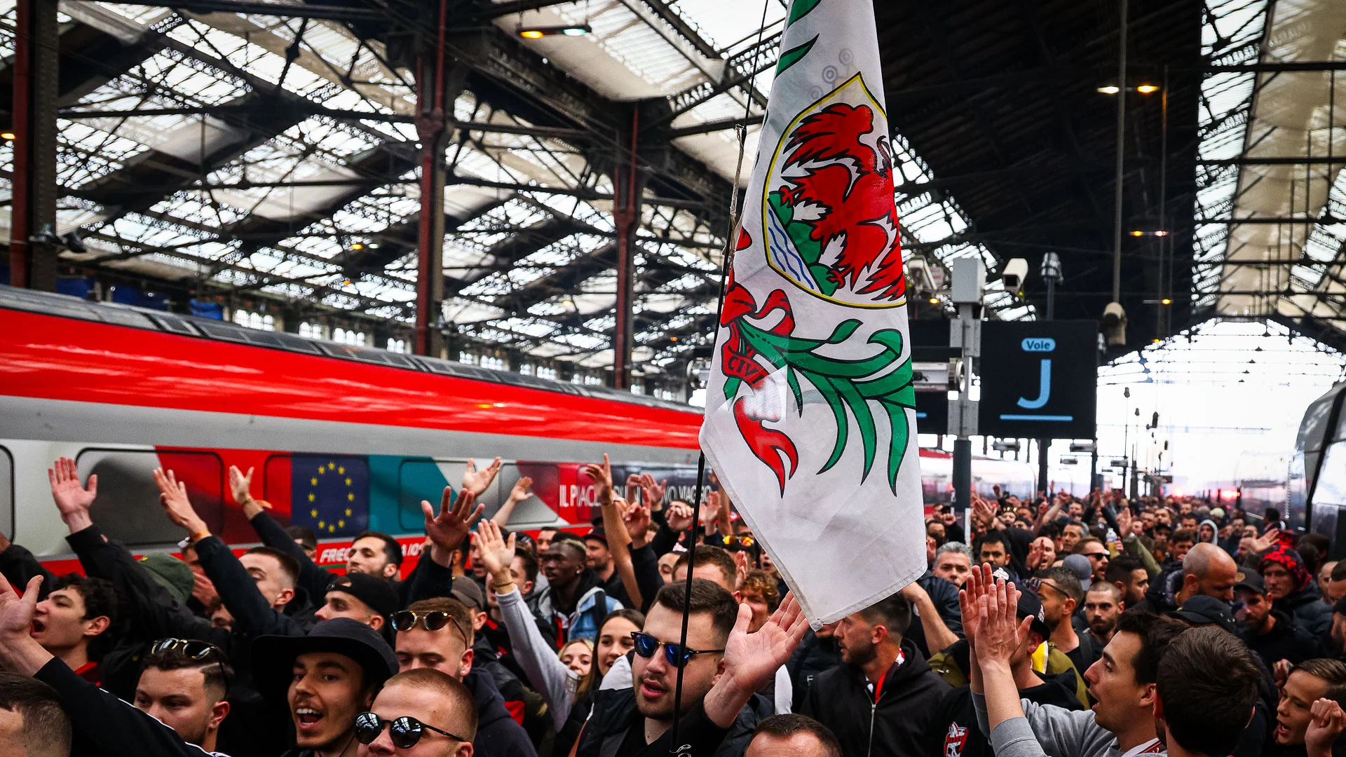 Supporters de l'OGC Nice avec drapeau aigle sur un quai de TGV, départ pour la finale de Coupe de France 2026