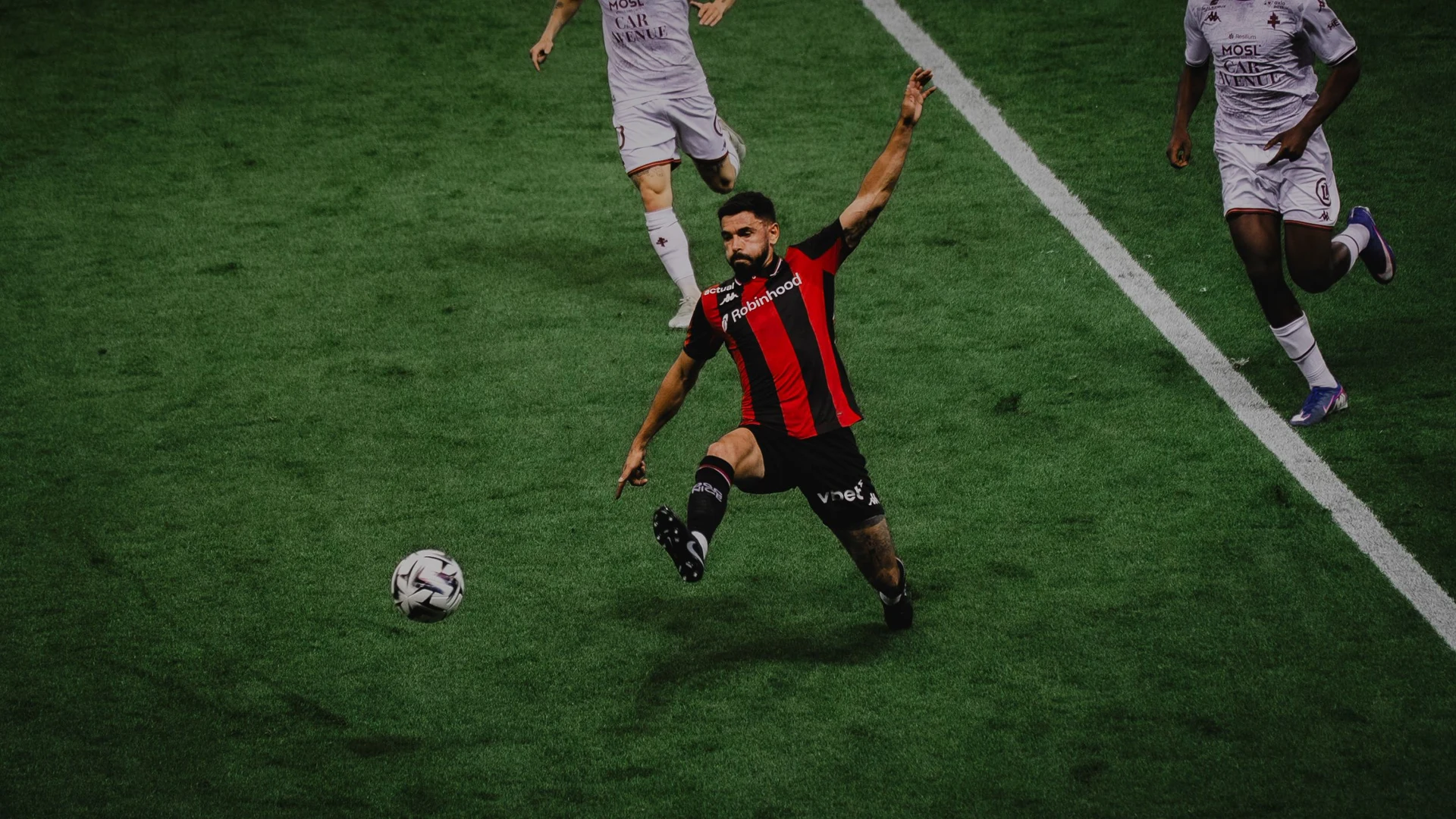Attaquant de l'OGC Nice frappe la balle face à des défenseurs du FC Metz lors de la 34e journée de Ligue 1