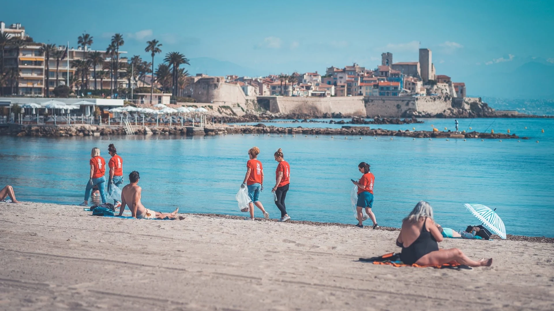 Bénévoles en t-shirt rouge sur la plage des Salis à Antibes pour le nettoyage citoyen RedDay