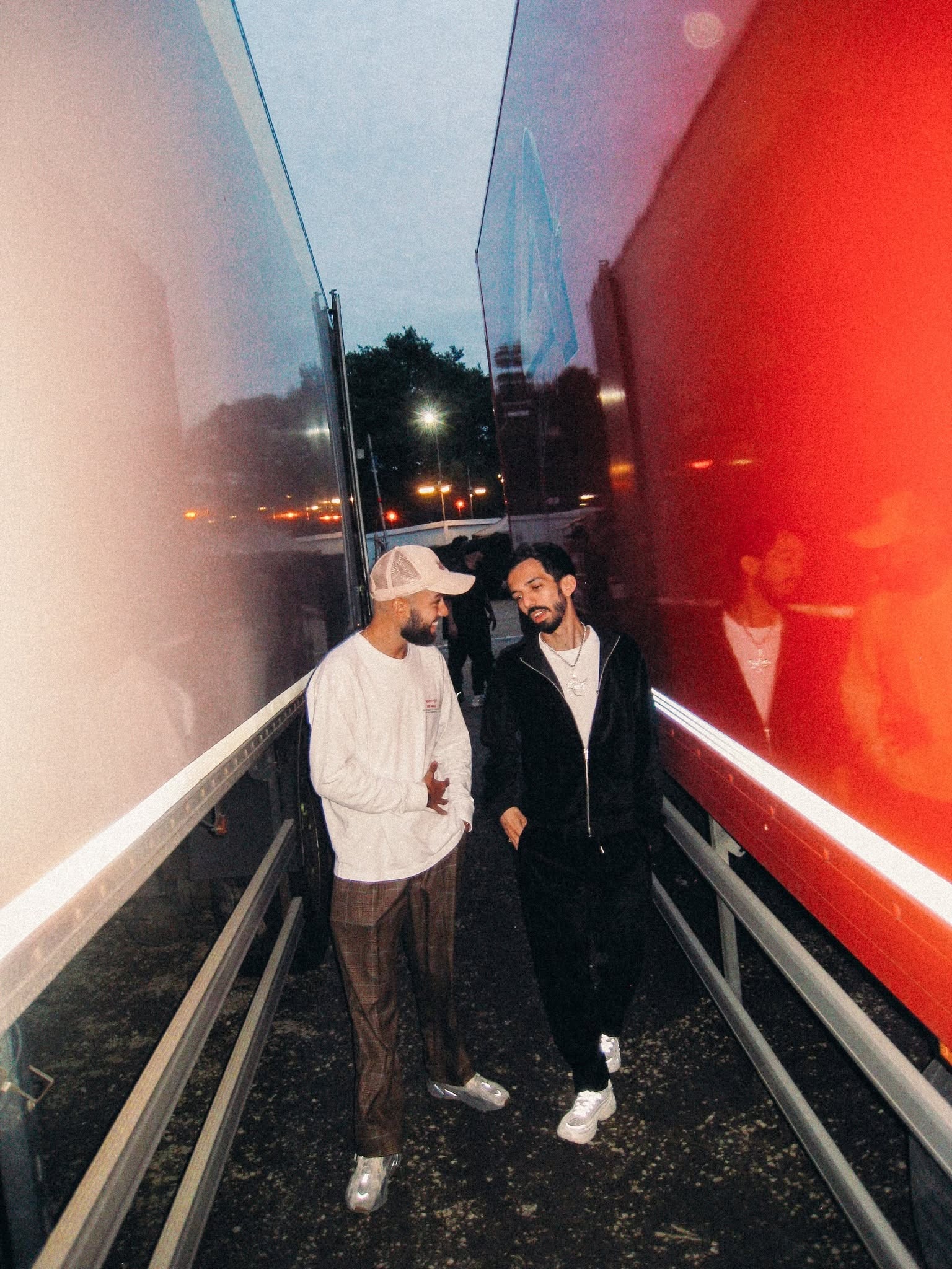 Bigflo et Oli dans un couloir baigne de lumieres rouge et bleue