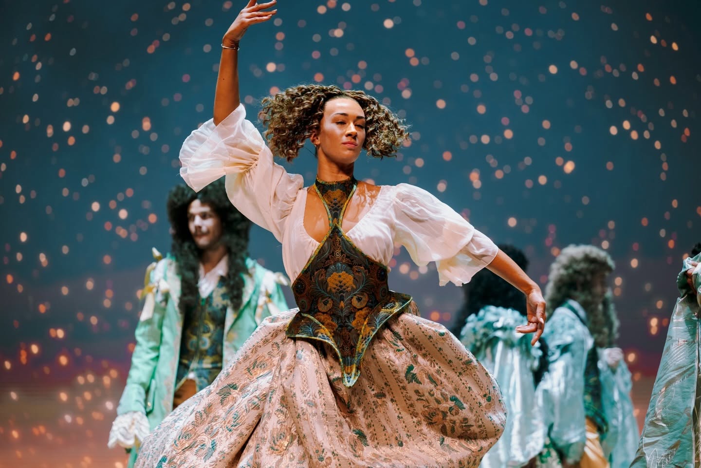 Danseuse en robe baroque tournoyant sous un ciel étoilé dans Le Roi Soleil