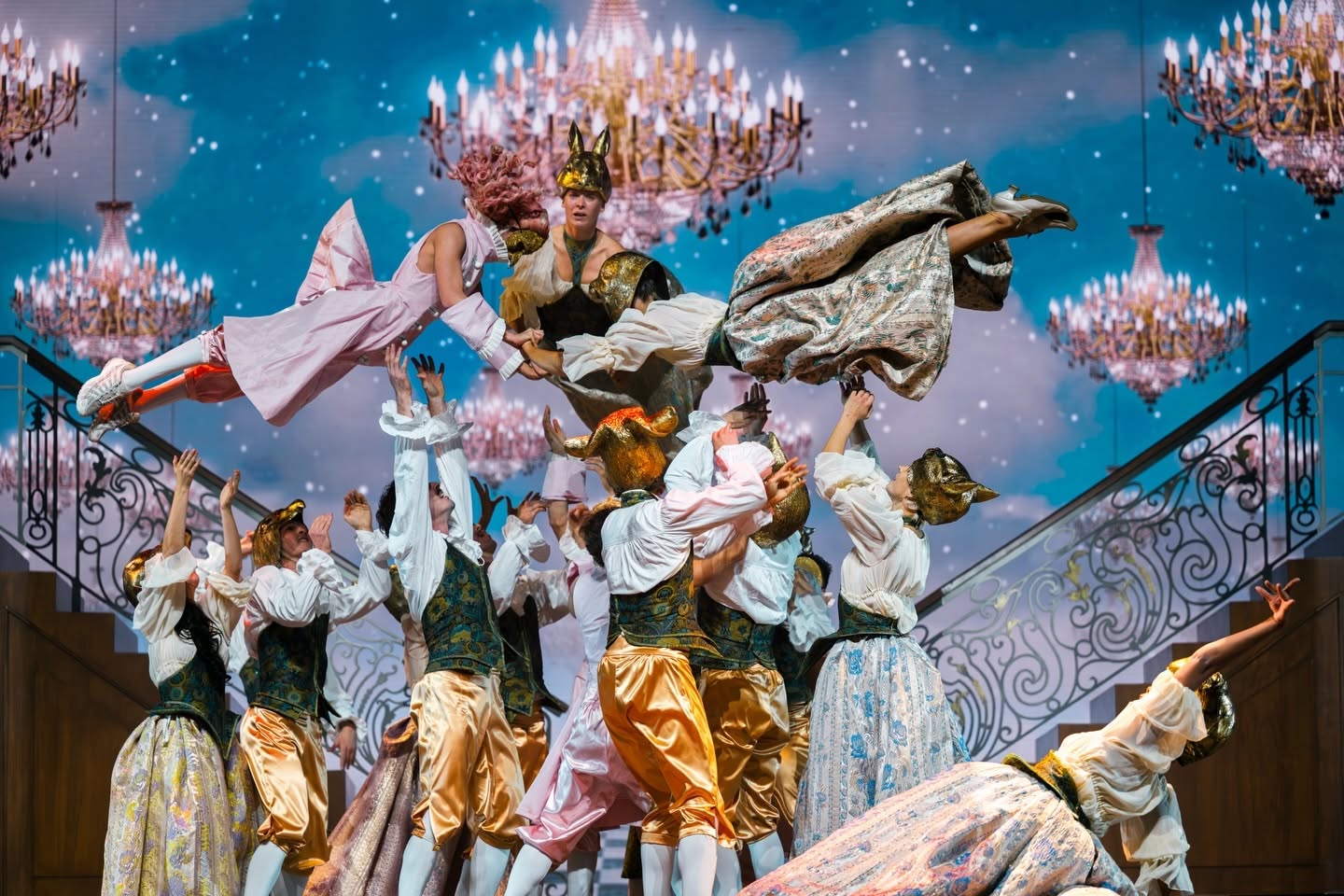 Danseurs masqués soulevés sous des lustres dans la comédie musicale Le Roi Soleil
