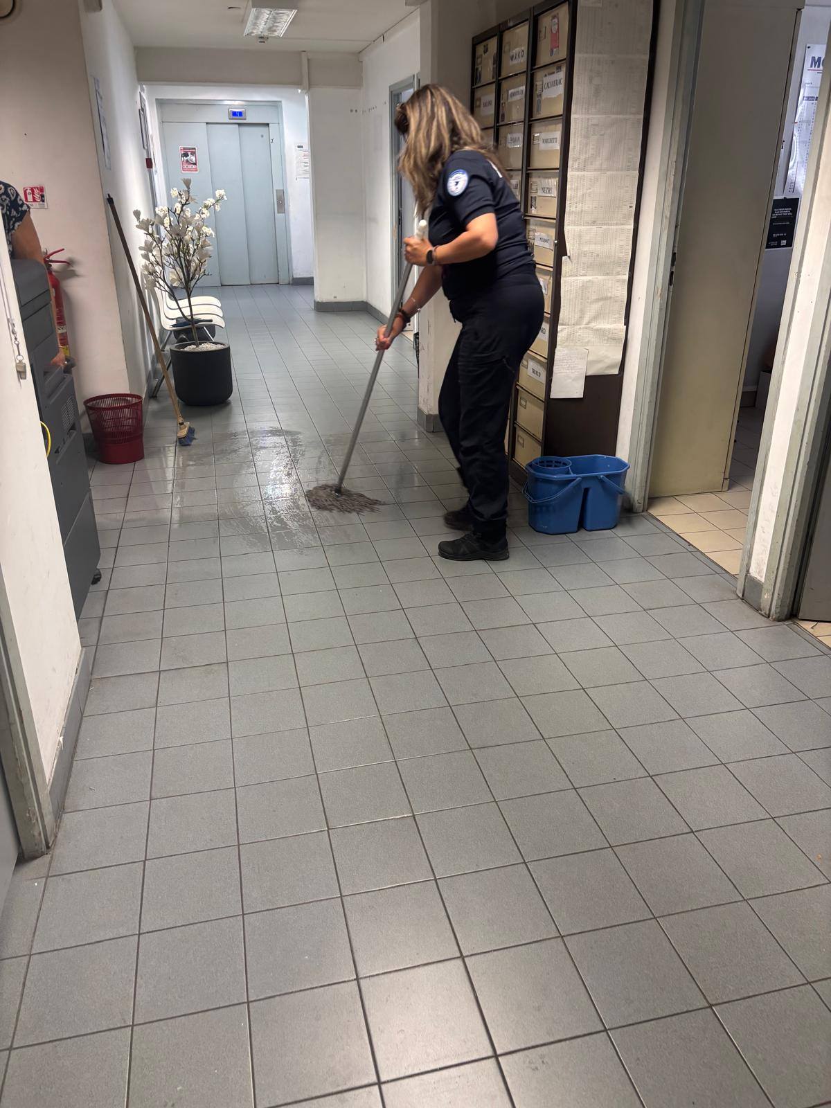Une policière passe la serpillière dans un couloir du commissariat d’Antibes