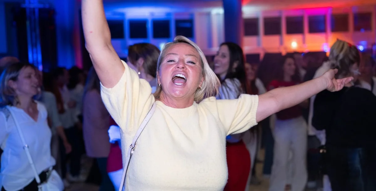 Femme bras levés en pleine fête à L'apéro des Frenchy à Nice