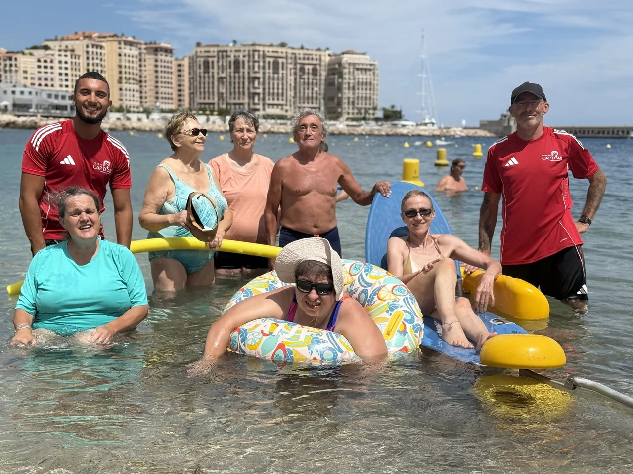 Groupe de baigneurs et handiplagistes dans l'eau à la plage Marquet, Cap-d'Ail