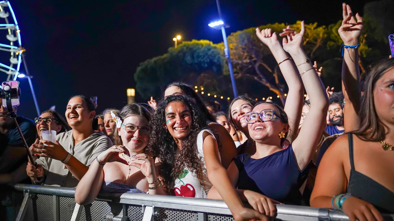 Jeunes festivaliers souriants au premier rang devant la scène des Nuits Carrées
