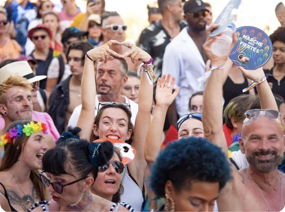 Foule joyeuse et pancarte Marche des fiertés lors de la Pink Parade à Nice