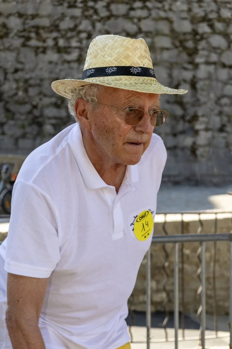 Nelson Monfort en chapeau de paille et polo blanc au tournoi de pétanque de Saint-Paul