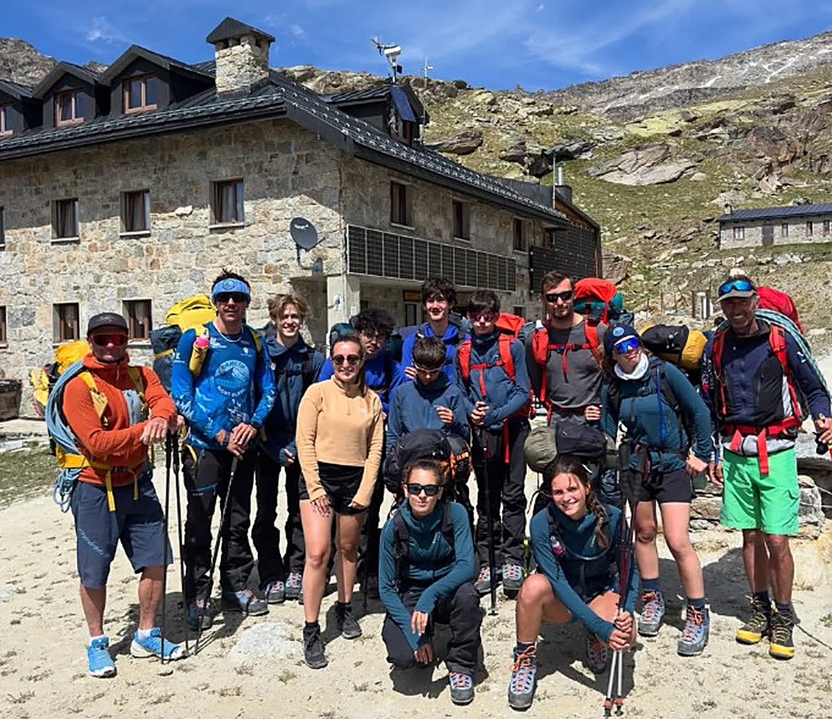 Le groupe d’adolescents niçois de Terr’a Loisirs, sacs au dos, devant un refuge de haute montagne
