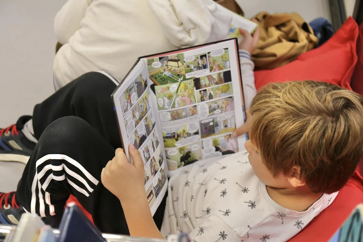 Enfant lisant une bande dessinée à la médiathèque d’Antibes