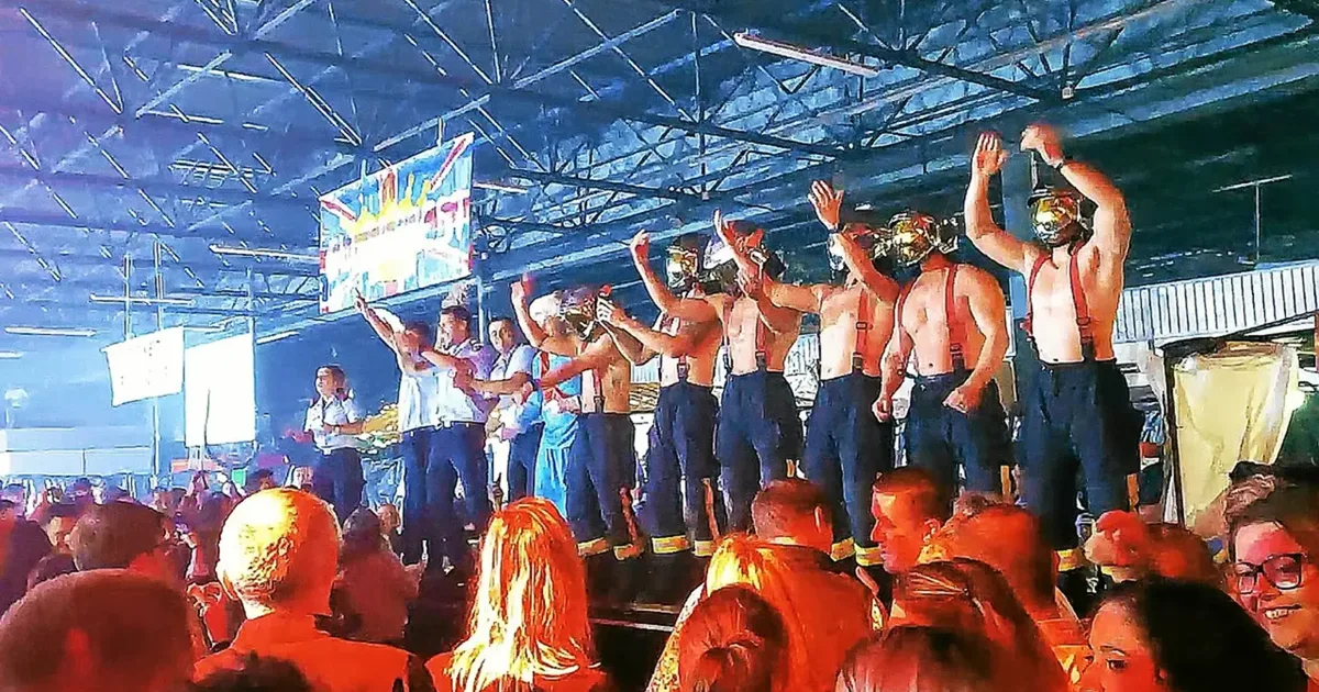 Pompiers casqués sur scène saluant la foule au bal de Menton