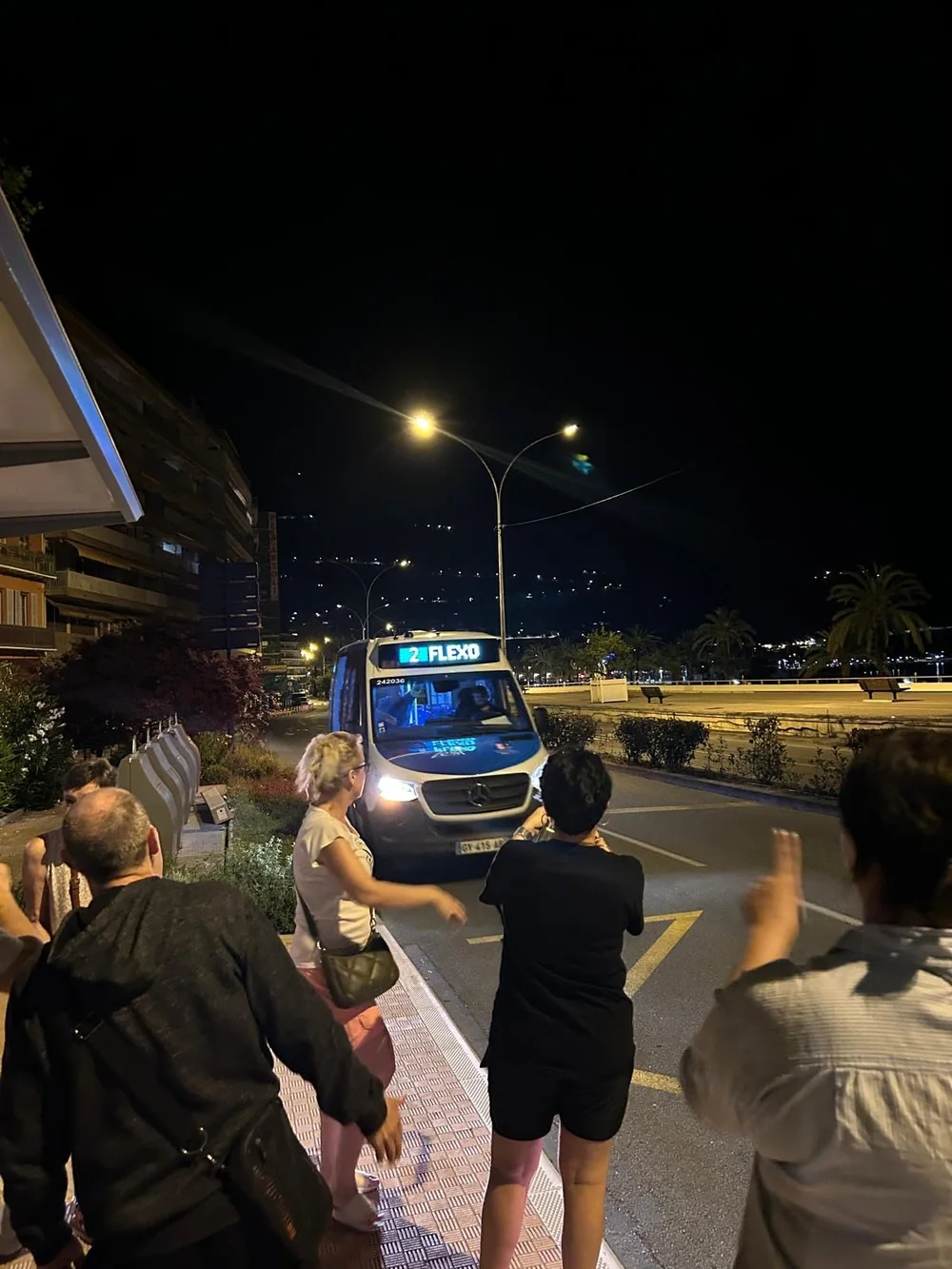 Le minibus Flexo de nuit sur le front de mer de Menton, des voyageurs montent à bord