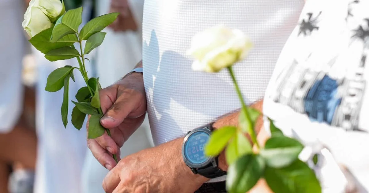 Roses blanches tenues à la main lors de la marche hommage à Nice