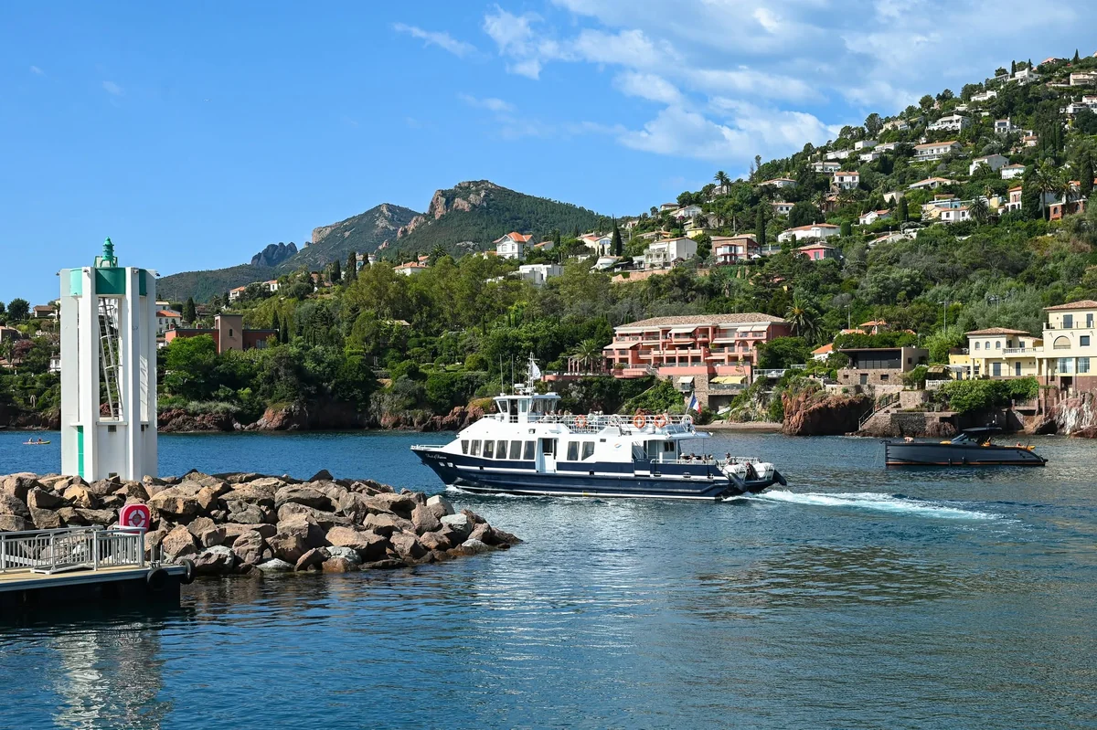 La navette maritime Estérel entre au port de Théoule-sur-Mer, massif de l’Estérel derrière