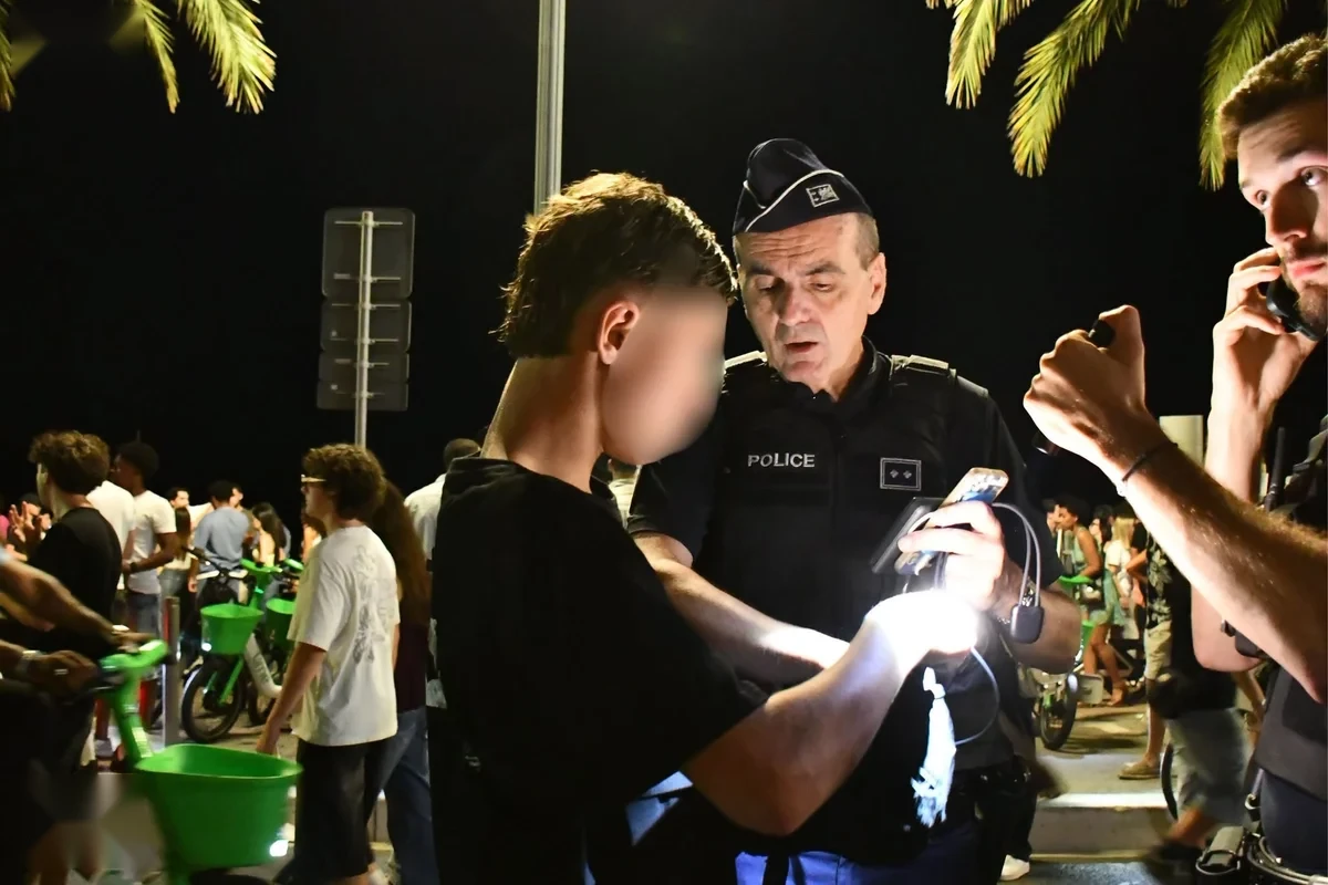 Contrôle de police de nuit sur le quai des États-Unis à Nice, foule et palmiers