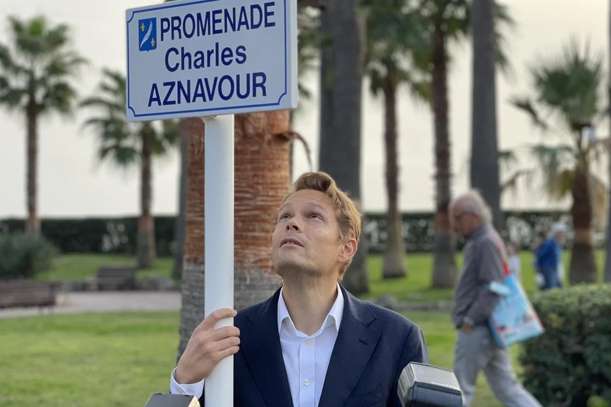 Nicolas Aznavour sous la plaque de la promenade Charles Aznavour à Cannes
