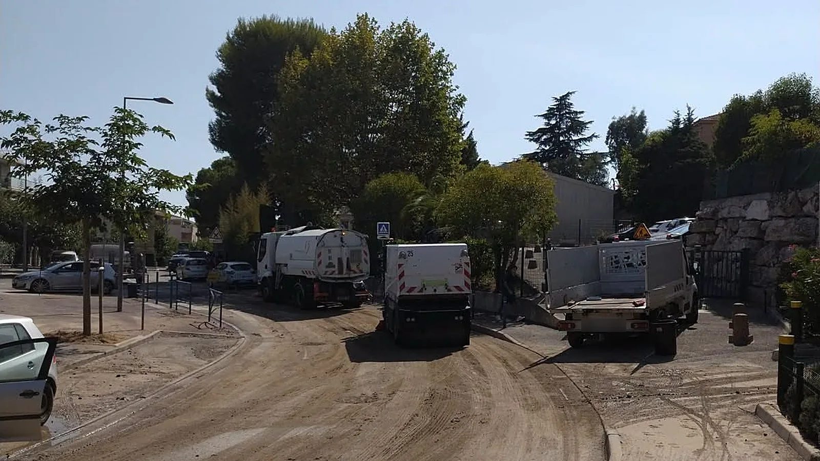 Deux balayeuses des services techniques nettoient la boue laissée par la fuite, avenue du Docteur Lefebvre