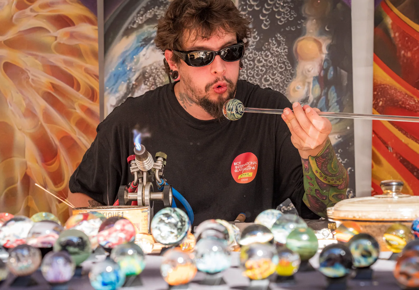 Un chalumiste façonne une bille de verre au village des chalumistes du Biot International Glass Festival, place des Arcades à Biot