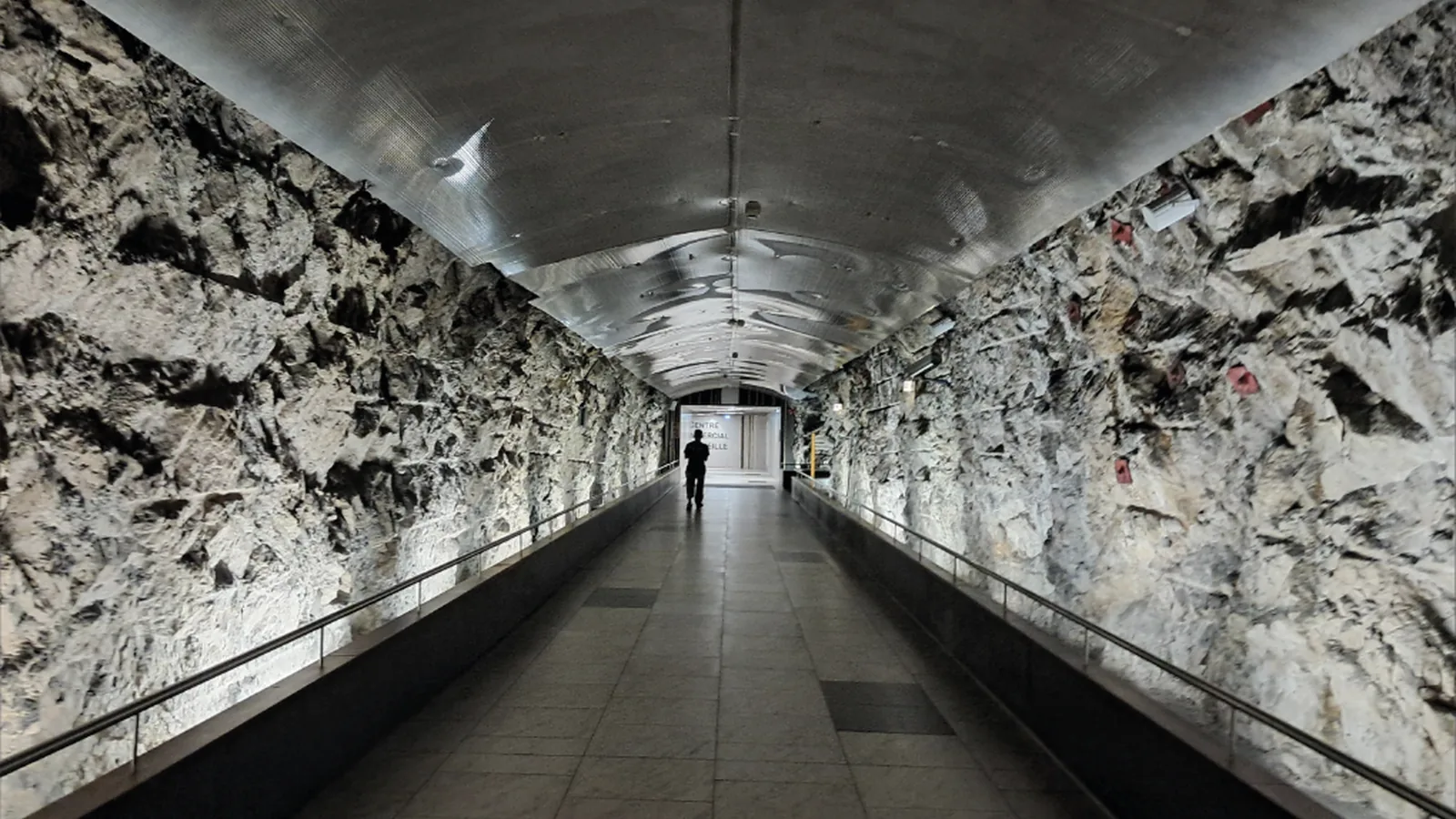 Tunnel souterrain sous Monaco, parois de roche brute et voûte métallique