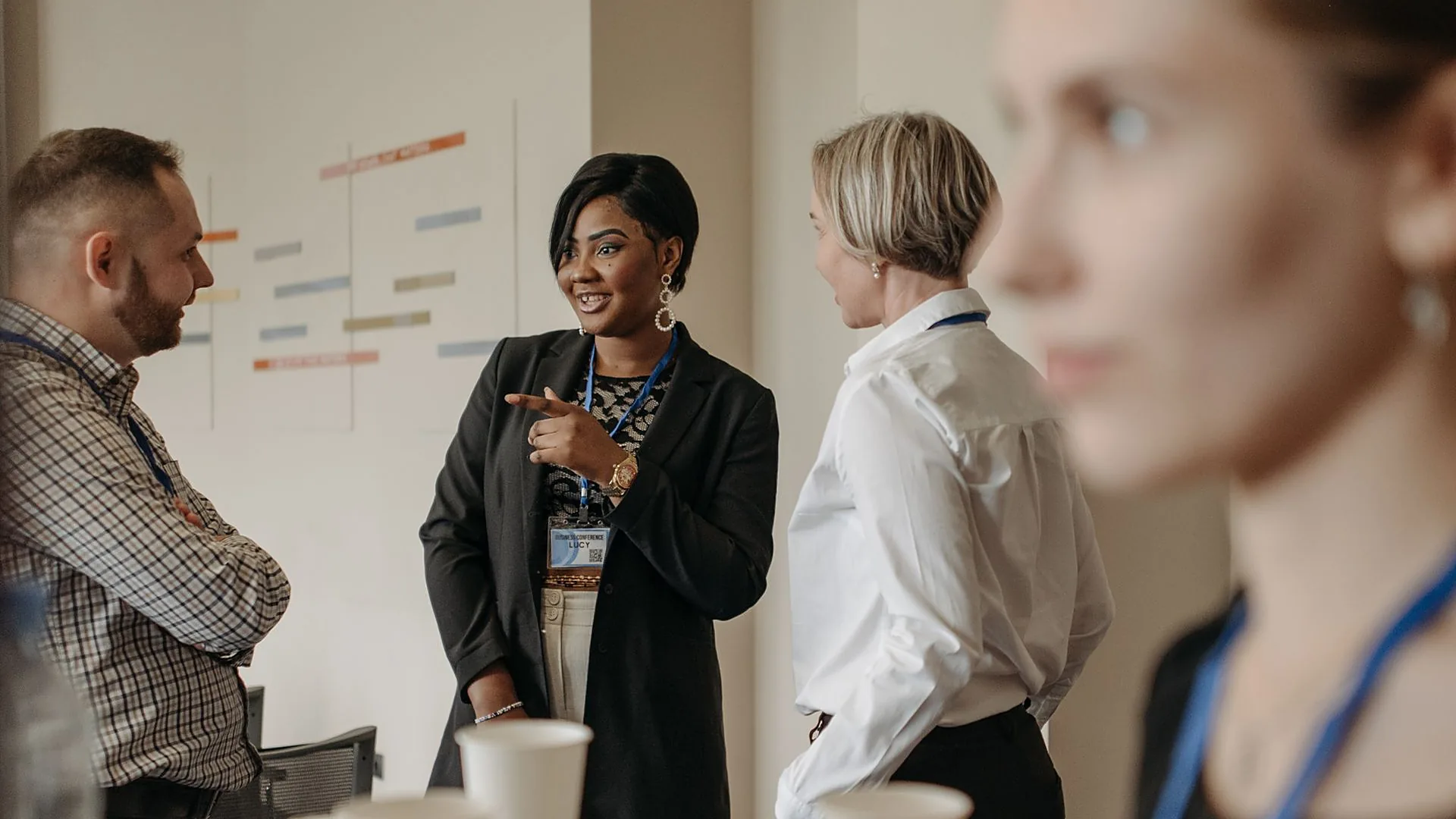 Des entrepreneurs discutent avec des conseillers, badge autour du cou, lors d'un rendez-vous professionnel
