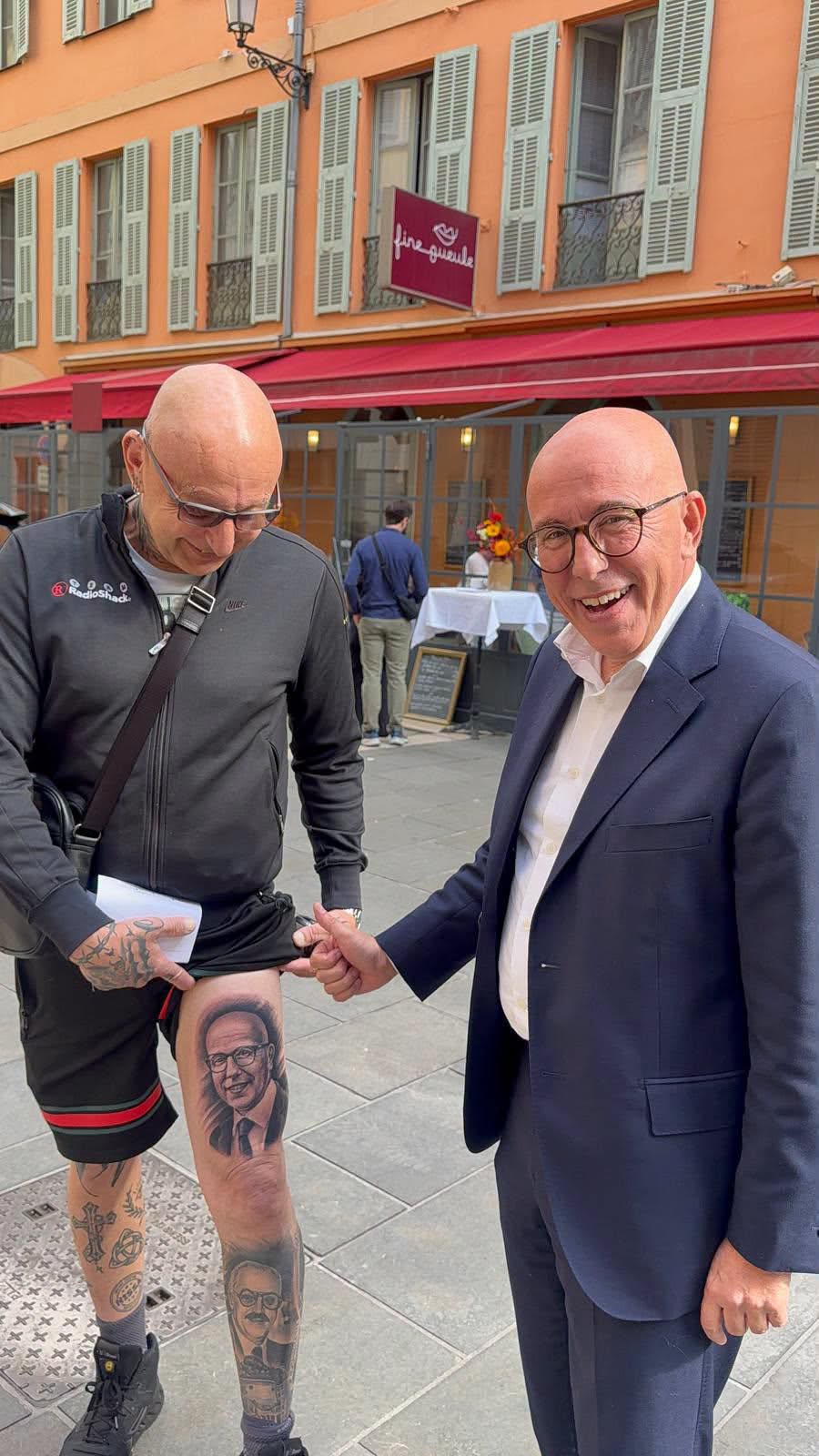 Éric Ciotti sourit à côté d’un homme qui montre son portrait tatoué sur la cuisse, rue de Foresta à Nice