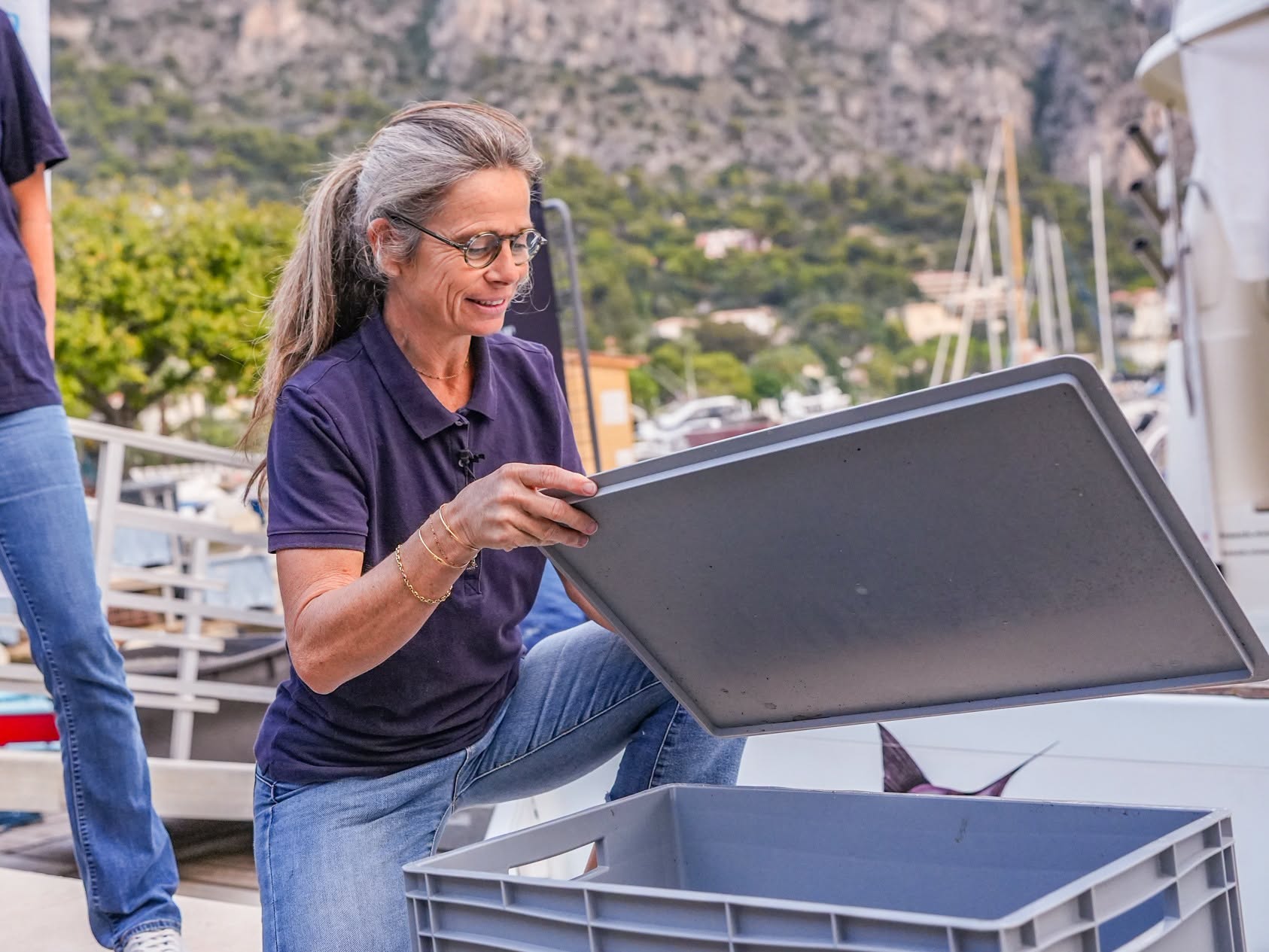 Une membre d’Émergence ouvre la caisse de transport sur le quai du port de Beaulieu
