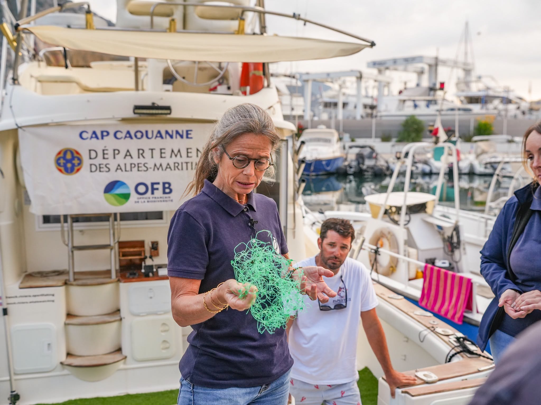 Une soigneuse penchée au-dessus de l’eau remet une tortue à la mer depuis un bateau