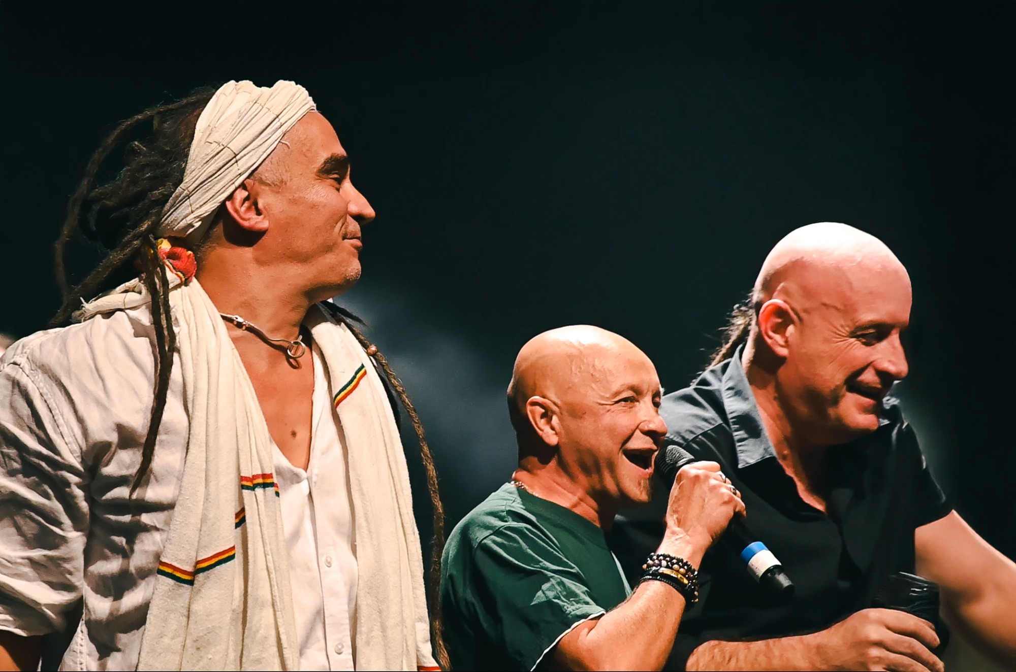 Trois chanteurs du collectif Ensemble !!! rient et chantent ensemble au micro